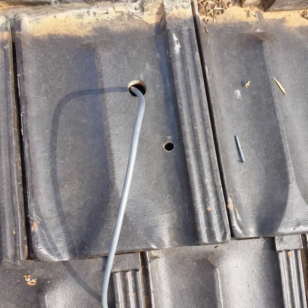 Photo of hole in a tile where Gen 3 ethernet cable will pass through for Starlink Gen 3 tile roof mount kit installation