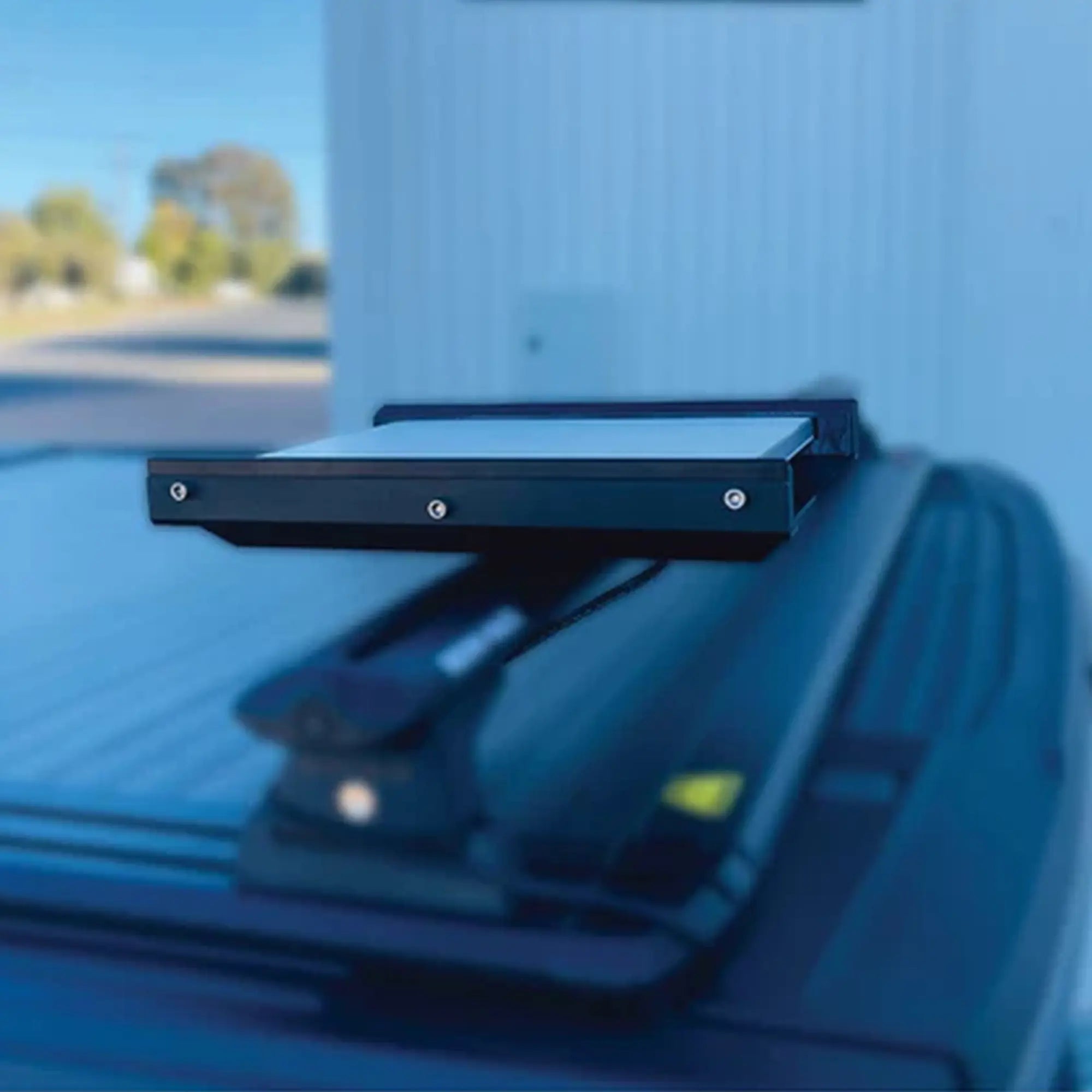 Black roof rack mounted on a vehicle with a blurred outdoor background starlink Mini