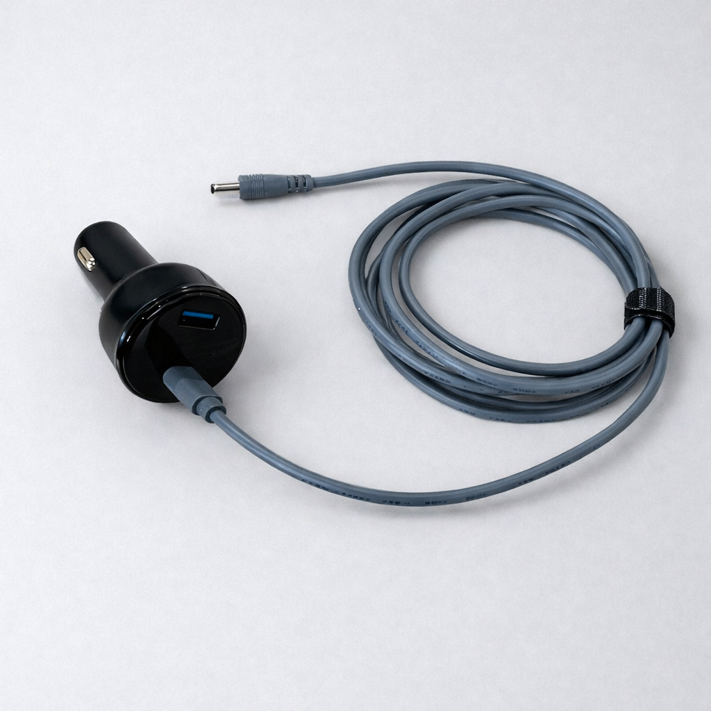 Spacetek charging cable with a barrel plug connected to a black car charger, neatly coiled and secured with a Velcro strap, shown on a neutral grey background