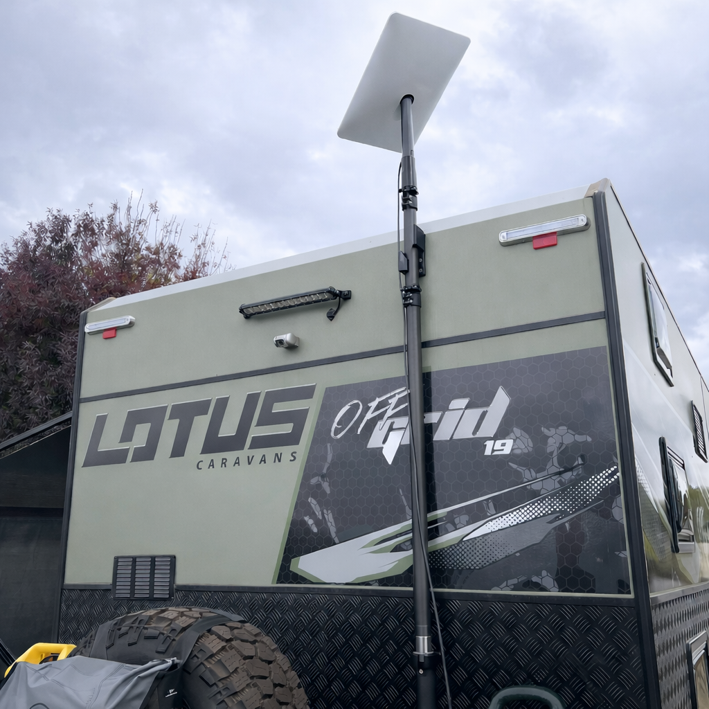 Starlink Gen 2 receiver mounted on Spacetek carbon fibre telescopic pole installed on Lotus Off Grid 19 caravan under cloudy sky.