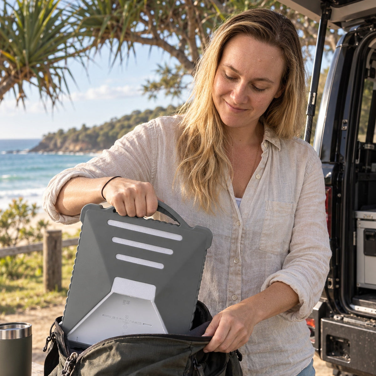 Grey Starlink Mini silicone protective cover with carry handle being packed into a travel bag for impact protection.